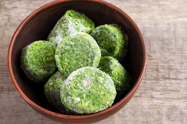 Frozen spinach on wooden background.