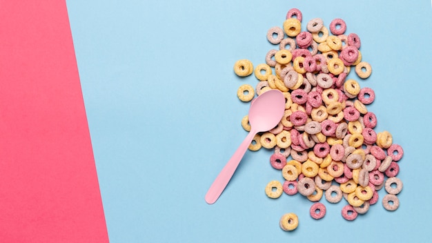 Fruit cereal loops in a pile with pink spoon