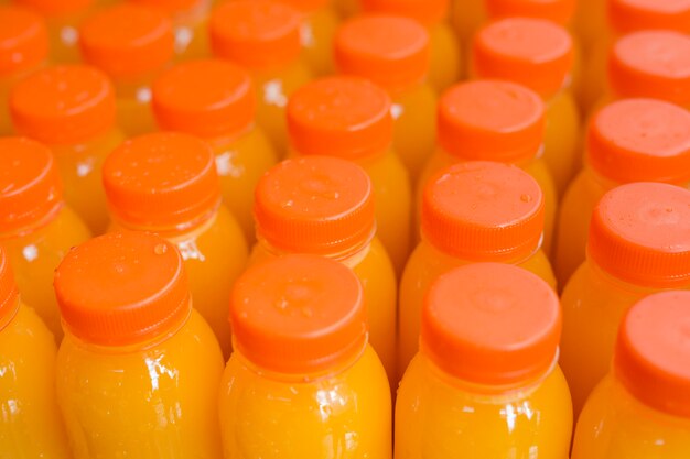 Фруктовый сок в пластиковой бутылке с оранжевой закрытой крышкой