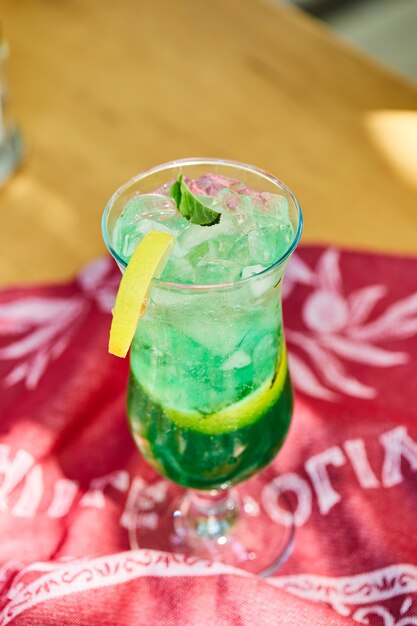 A fruit lemonade on wooden table with red cloth