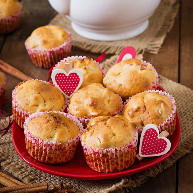 Fruit muffins with nutmeg and allspice in a wicker basket on a wooden table