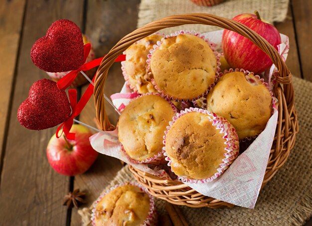 Fruit muffins with nutmeg and allspice in a wicker basket on a wooden table