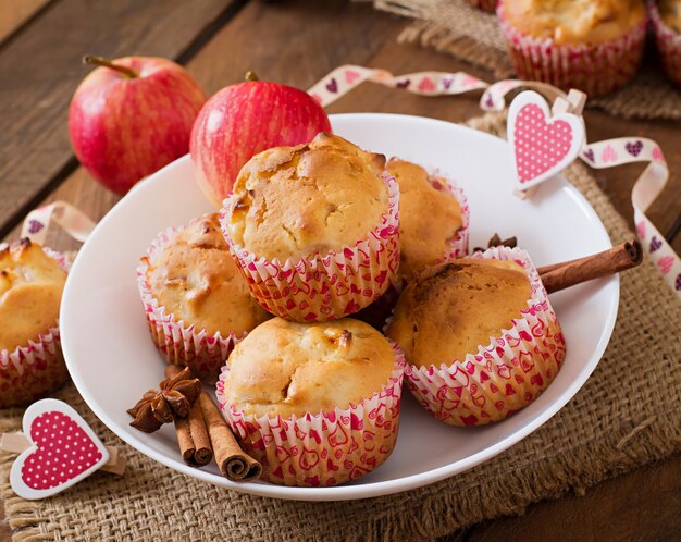 Fruit muffins with nutmeg and allspice in a wicker basket on a wooden table