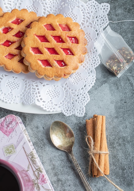 Fruit pies and cinnamon sticks on marble.