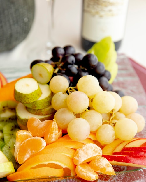 Fruit plate grape orange kiwi apple side view