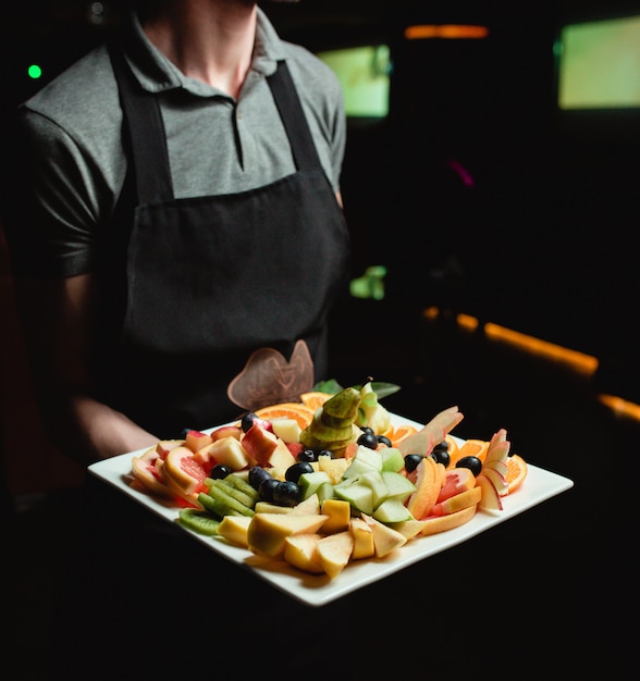 Free photo fruit plate on the hand of waiter