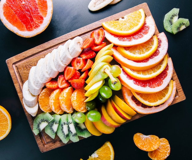 Free photo fruit platter with mixed sliced fruits.