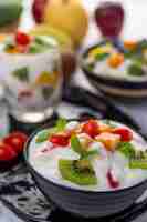 Free photo fruit salad in a bowl on the wooden floor.