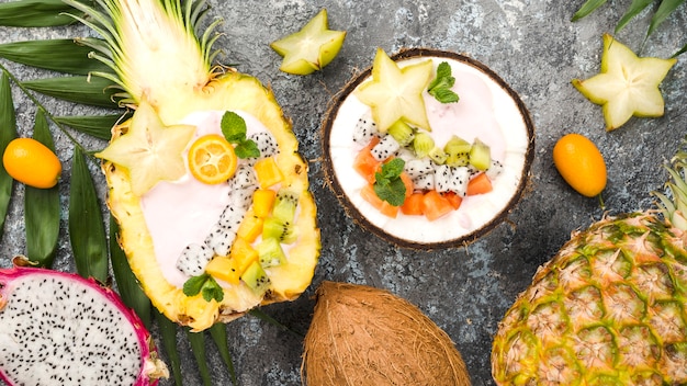 Fruit salad in coconut and pineapple plates top view