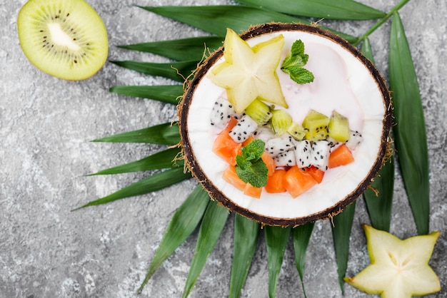 Fruit salad in coconut plate and half of kiwi