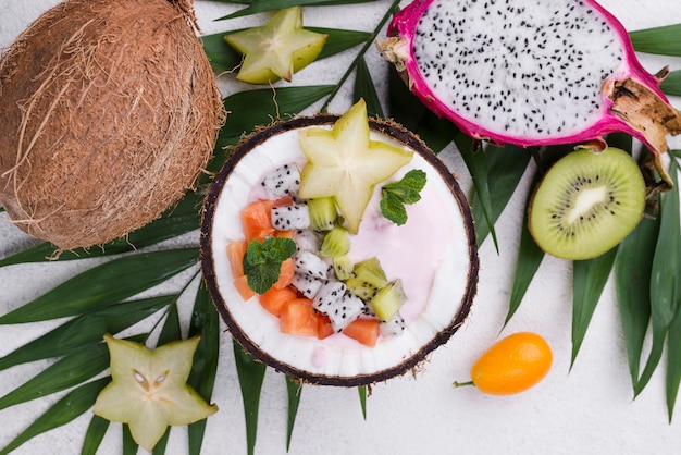 Free photo fruit salad in coconut plate and yogurt