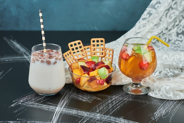 Fruit salad with crackers and drinks.