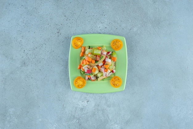 Fruit and vegetable salad with mixed ingredients on blue.