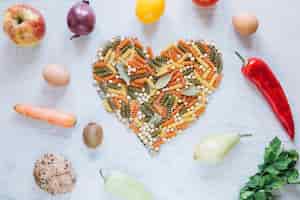 Бесплатное фото Фрукты и овощи вокруг сердца макаронных изделий