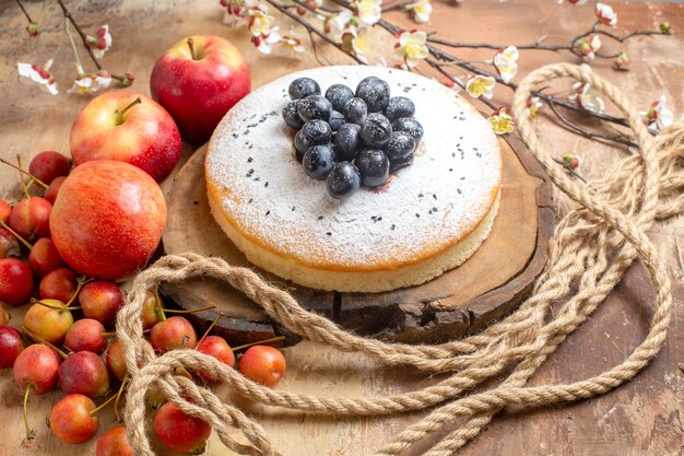 fruits an appetizing cake with grapes three apples and berries on the table