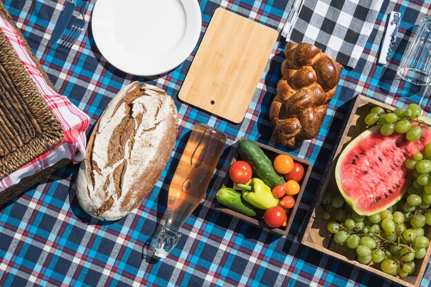 Fruits; baked bread and vegetables on checkered cloth