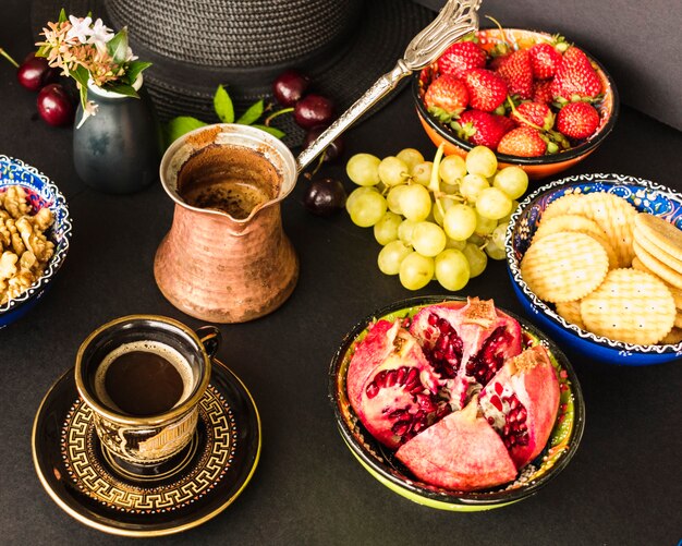 Fruits, biscuits and walnut with tea on the table