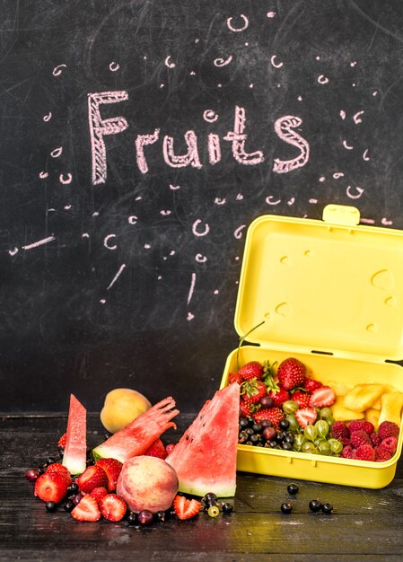 Fruits on black table with inscription on blackboard