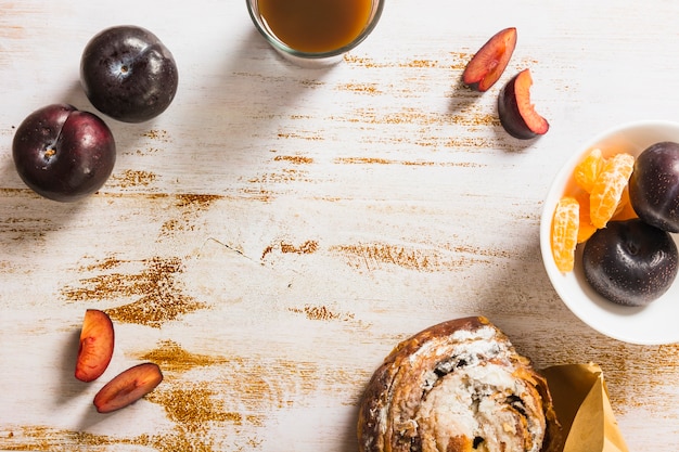 Free photo fruits and bun near drink