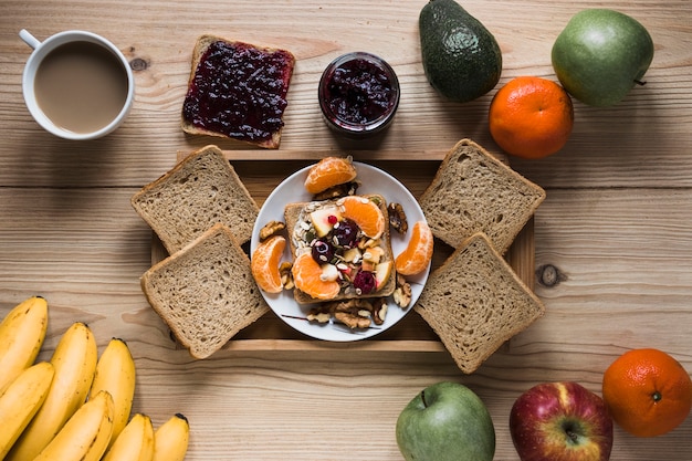 Fruits and coffee around tray with breakfast