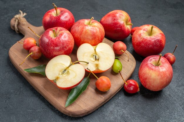 fruits fruits and berries on the wooden board next to the apples with leaves