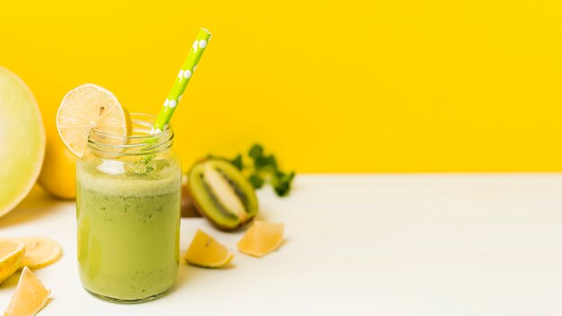 Fruits and glass with cocktail and straw