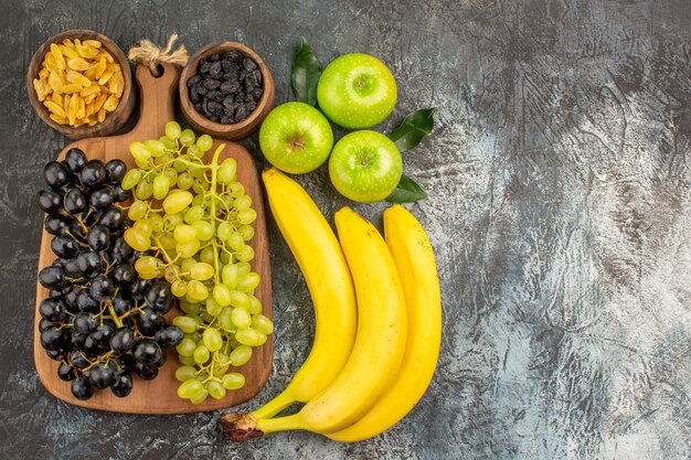 fruits grapes on the board dried fruits bananas three apples with leaves