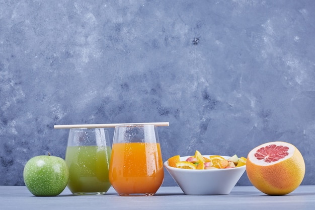 Free photo fruits with salad and glasses of juice.