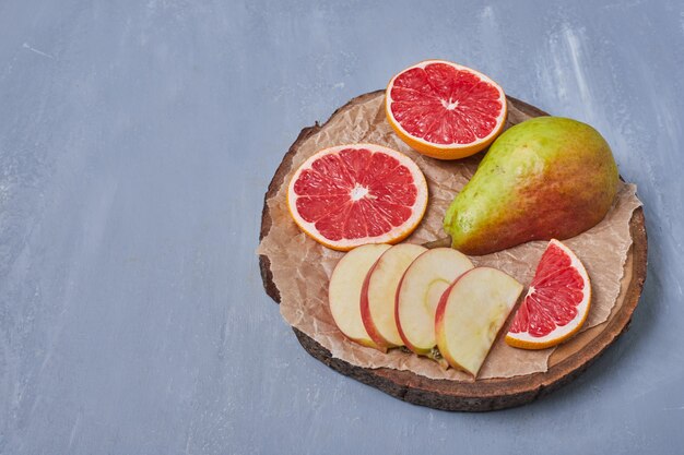 Fruits on a wooden board on blue