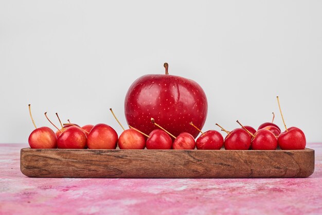 Fruits on wooden board on pink.