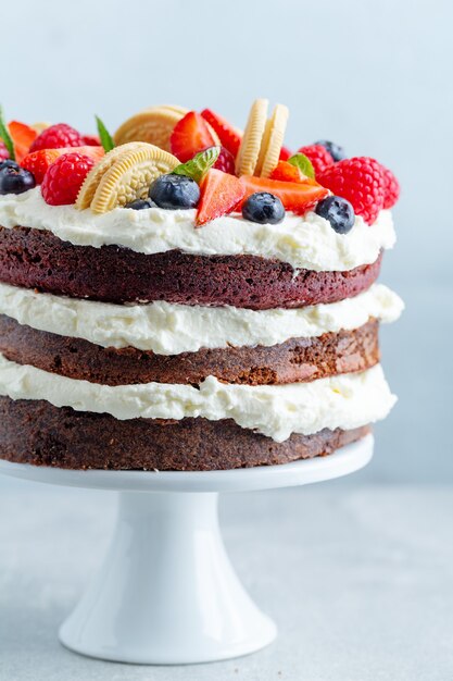 Fruity cake with fresh fruits and cream on stander