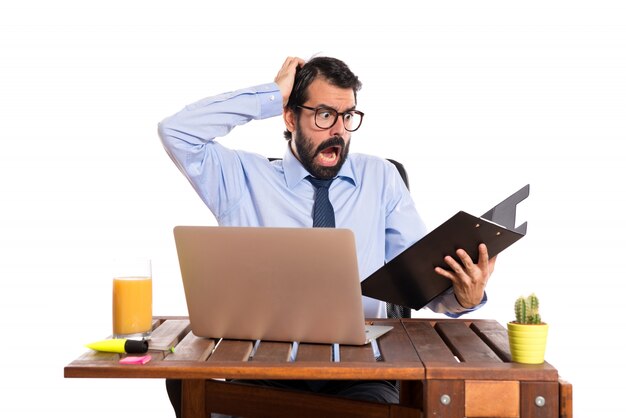 Frustrated businessman in his office with his folder