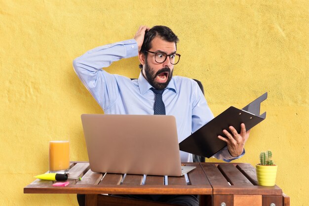 Frustrated businessman in his office with his folder