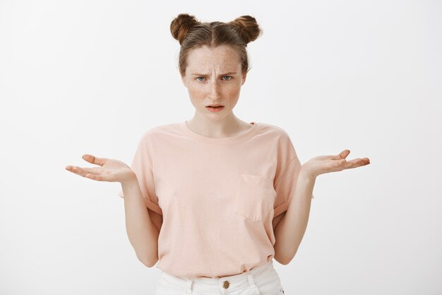 Frustrated and concerned teenage girl posing against the white wall