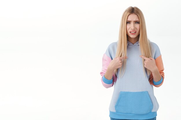 Frustrated and confused blonde glamour girl with blonde hair, looking offended or accused