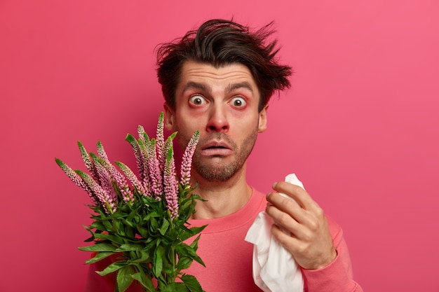 欲求不満の病人は花粉アレルギーでくしゃみをし、ハンカチを持って鼻をこすり、春の花にアレルギーがあり、目が腫れ、治療が必要で、拭き取りをします。季節性疾患
