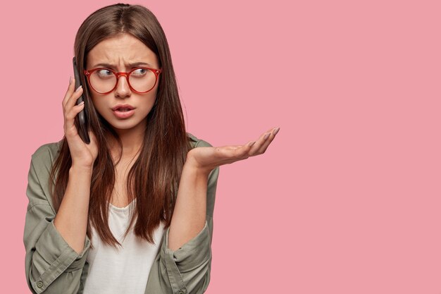 Frustrated student posing against the pink wall