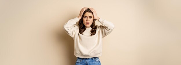 Foto gratuita donna frustrata e turbata che affronta il disastro tenendosi per mano sulla testa in preda al panico che sembra ansiosa