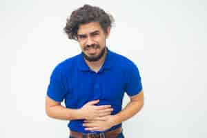 Free photo frustrated unhappy guy suffering from belly ache