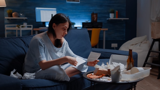 Frustrated woman breaking paper letter with banking termination notification