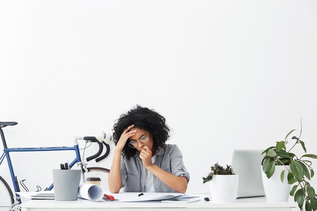 Frustrated woman engineer checking her technical drawings