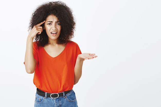 Frustrated woman with afro hairstyle posing in the studio