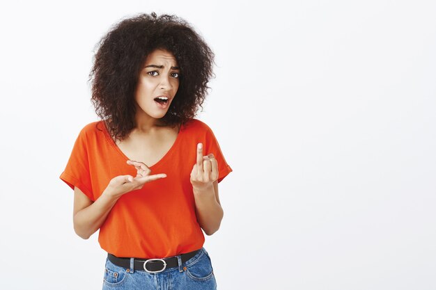 frustrated woman with afro hairstyle posing in the studio