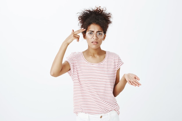 frustrated woman with afro hairstyle posing in the studio