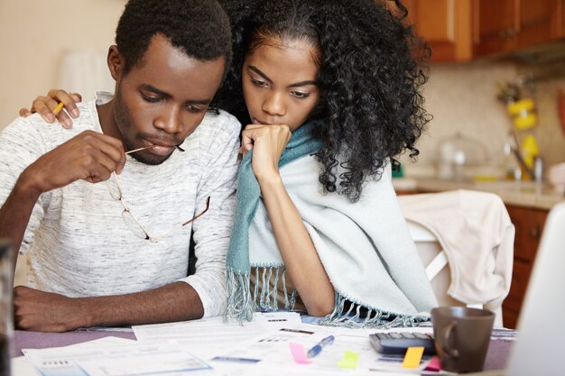 Frustrated young African couple having big problems paying utility bills