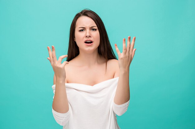 Frustrated young woman posing on blue