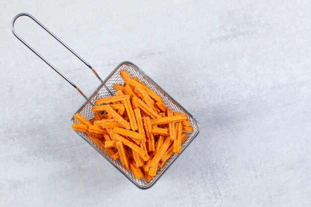 Free photo frying basket full with fresh chips over white.