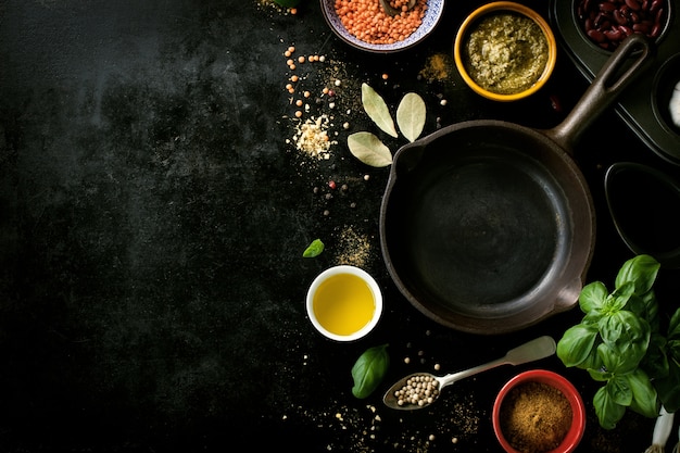 Frying pan empty with various spices in a black table