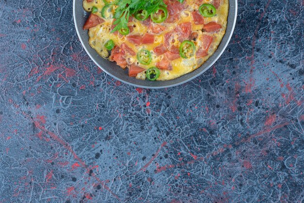 A frying pan of omelet with vegetables 