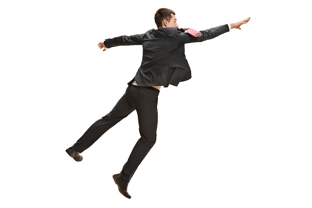 Full body jumping businessman or diplomat on white studio background. Serious young man in suit, red tie in jump in office.